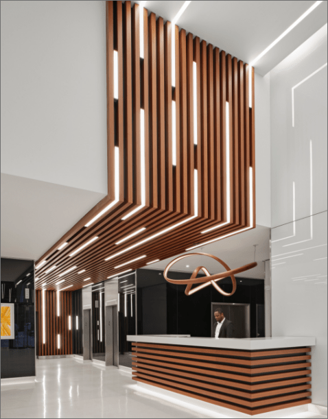 Modern lobby ceiling with wooden slats and ambient lighting at 575 Madison Avenue, a premier commercial property in Midtown Manhattan managed by Steinberg & Pokoik."